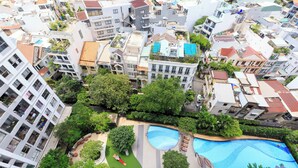 Un barrio residencial con piscina, abundante vegetación y varios edificios.