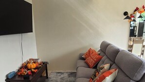 A living room with a grey sofa, a wooden coffee table with decorative pumpkins, a fluffy rug, and a ceiling light fixture. - Cozy apartment near the GNP stadium (Ciudad de México)