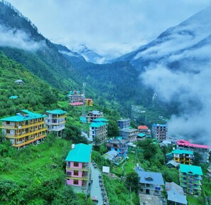 Un village de montagne aux bâtiments aux couleurs vives, aux rues étroites et à la végétation luxuriante.