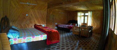 Eine Holzhütte mit zwei Betten, einem kleinen Tisch und einem Stuhl.