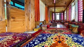A wooden interior with a long corridor, colorful rugs, and traditional decor.