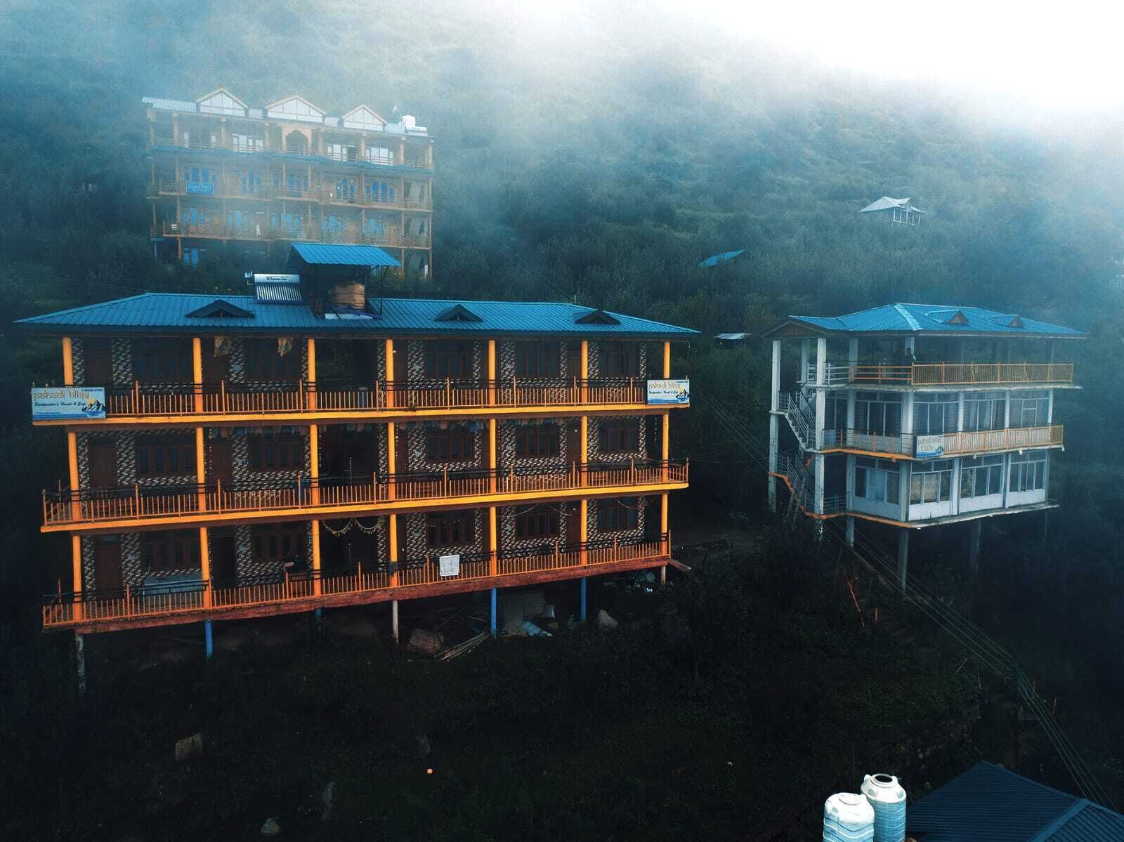 A multi-story building with balconies and a sign indicating it is a hotel.