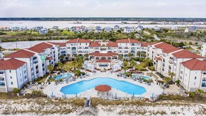 Ett hotellkomplex med flera byggnader, en central pool och ett område vid stranden.