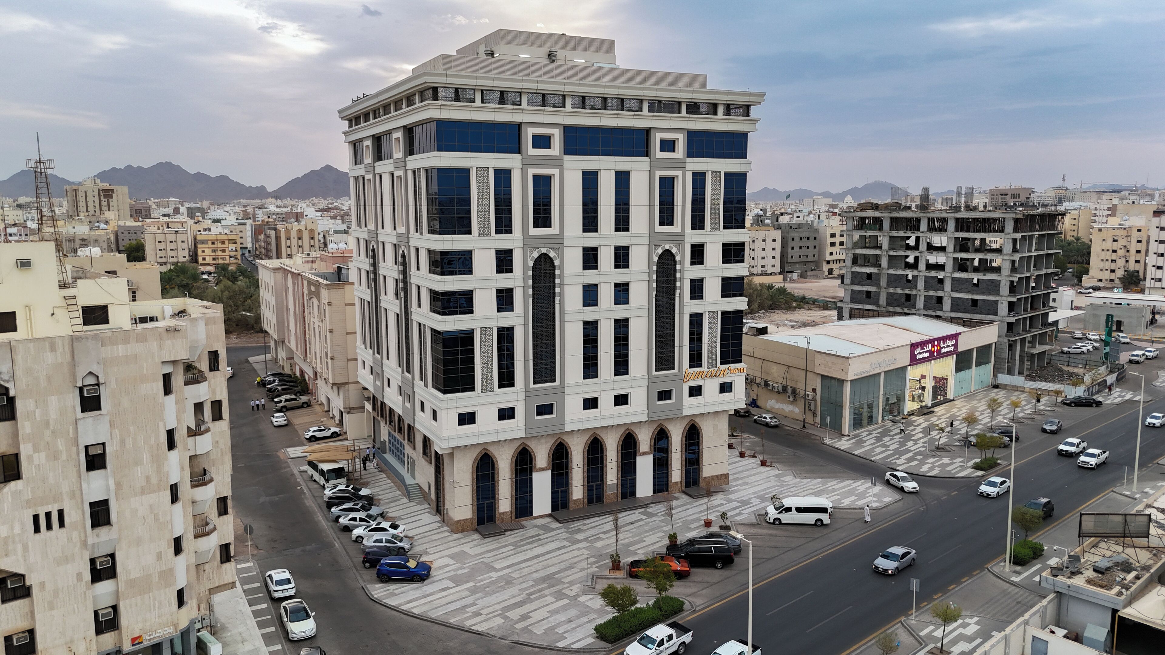 A modern building with a central courtyard, surrounded by parked cars and a busy street.