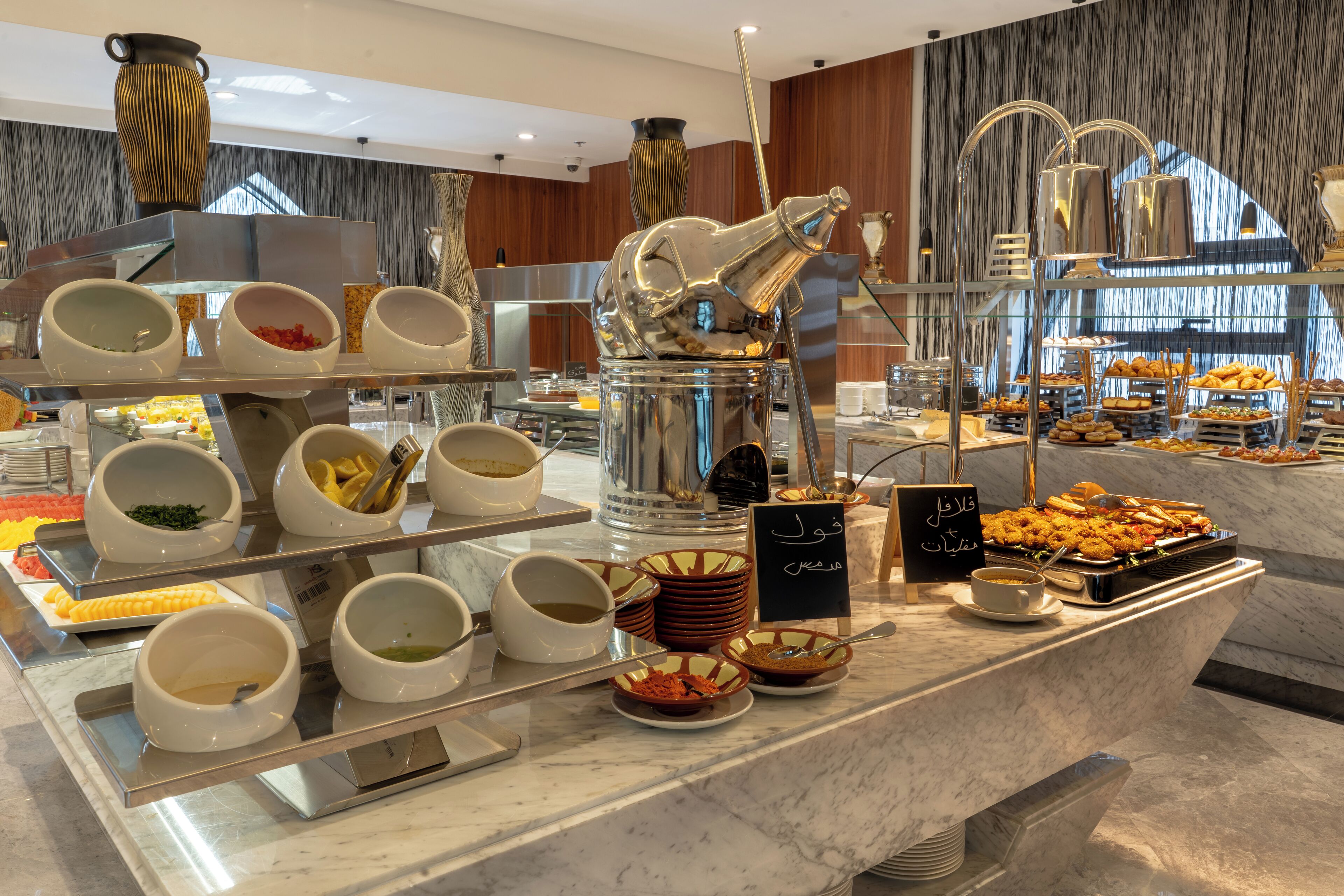 A buffet setup with various food items and serving utensils.