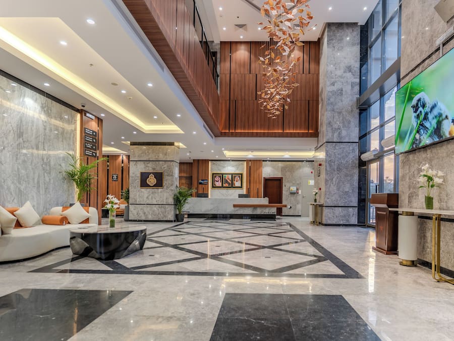 A spacious lobby with a reception desk, seating area, and a large screen displaying an image of a tiger.