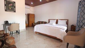 A bedroom with a bed, a desk, a chair, and a wardrobe. - LUIT BLUE HOMESTAY & RESORTS (Guwahati)