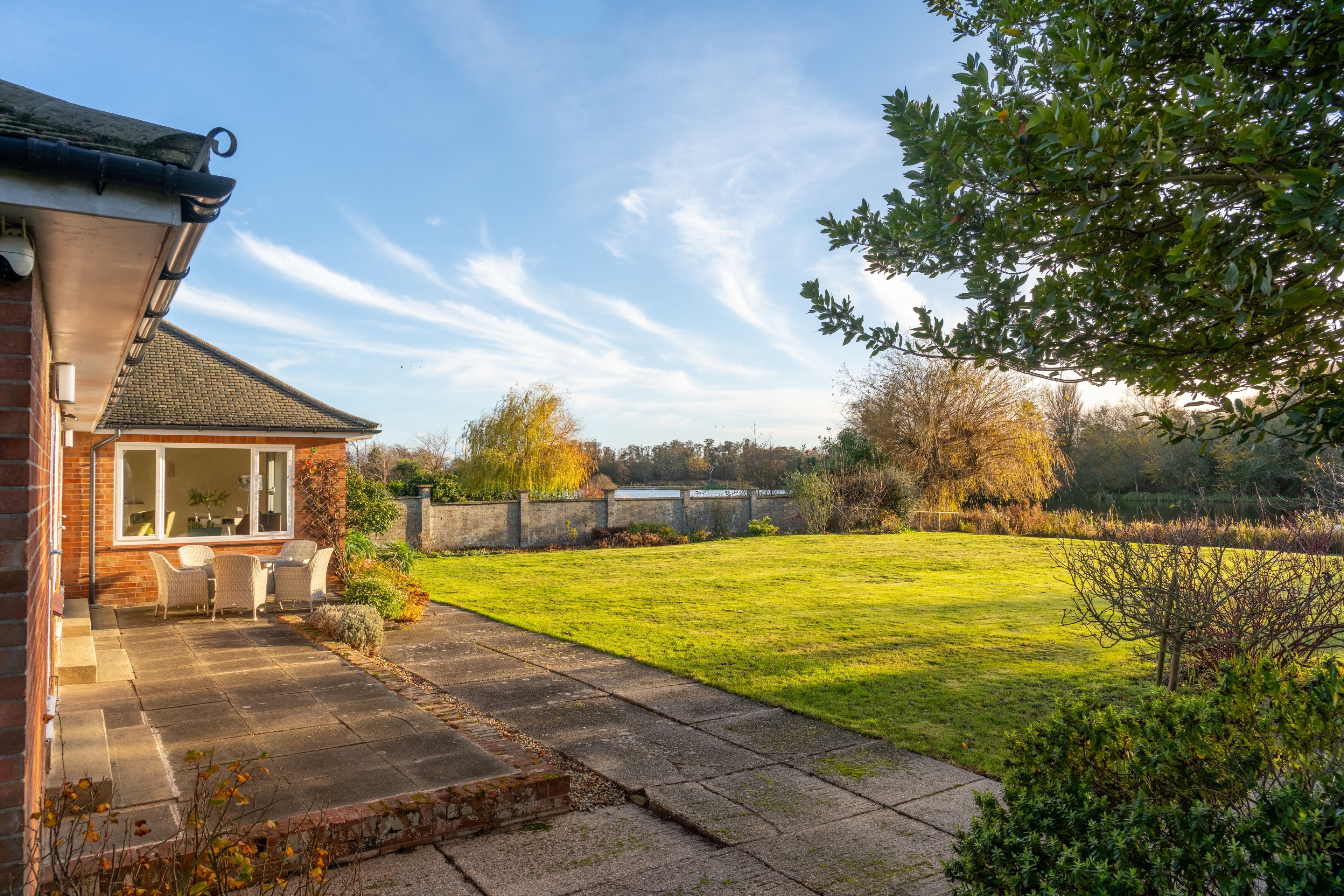A house with a patio, a lawn, and a view of the countryside.