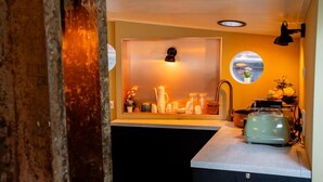 Une cuisine équipée d’un évier, d’un plan de travail et d’un grille-pain vintage.