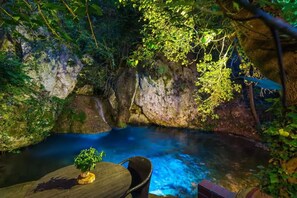 A serene outdoor pool area surrounded by lush greenery and rocky terrain. - Villa Myli Natural Paradise, quiet, unique, and 10 minutes from town center. (Mili)