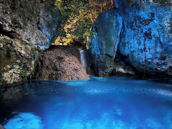 A natural pool with a waterfall, surrounded by rocky terrain and trees. - Villa Myli Natural Paradise, quiet, unique, and 10 minutes from town center. (Mili)