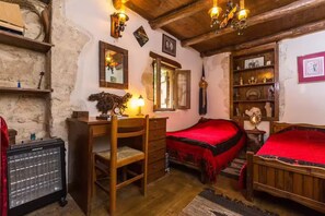 A rustic bedroom with a wooden bed, a desk with a chair, a bookshelf, and a mirror. - Villa Myli Natural Paradise, quiet, unique, and 10 minutes from town center. (Mili)