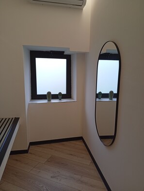 A room with a window, a mirror, and a radiator. - Borgo Double V (Napoli)