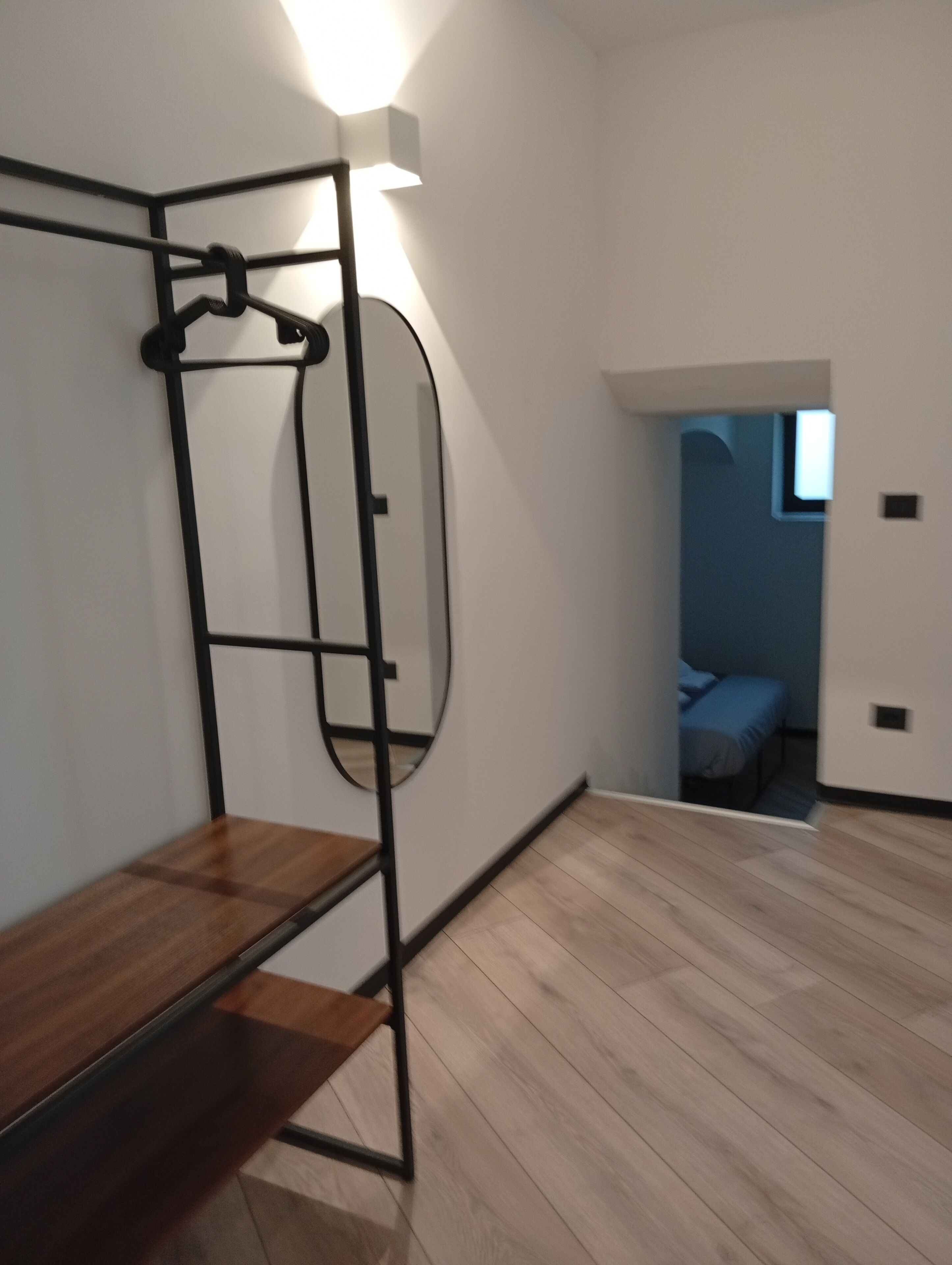 Una habitación con literas, una mesita pequeña y una lámpara fijada a la pared.