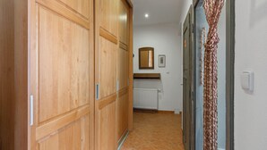 A hallway with wooden wardrobes, a radiator, and a mirror on the wall. - Relax na Šumavě by Interhome (Kasperske Hory)