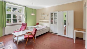 A room with a bed, a chair, a table, a wardrobe, and a window with curtains. - Relax na Šumavě by Interhome (Kasperske Hory)