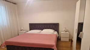 A bedroom with a bed, two bedside tables, a nightstand, a lamp, and a wardrobe. - Two-bedroom Apartment With Sea View (A1) (Trogir)