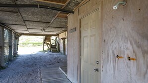 Une porte en bois avec une enseigne indiquant « Laverie » et un tuyau en métal au plafond.