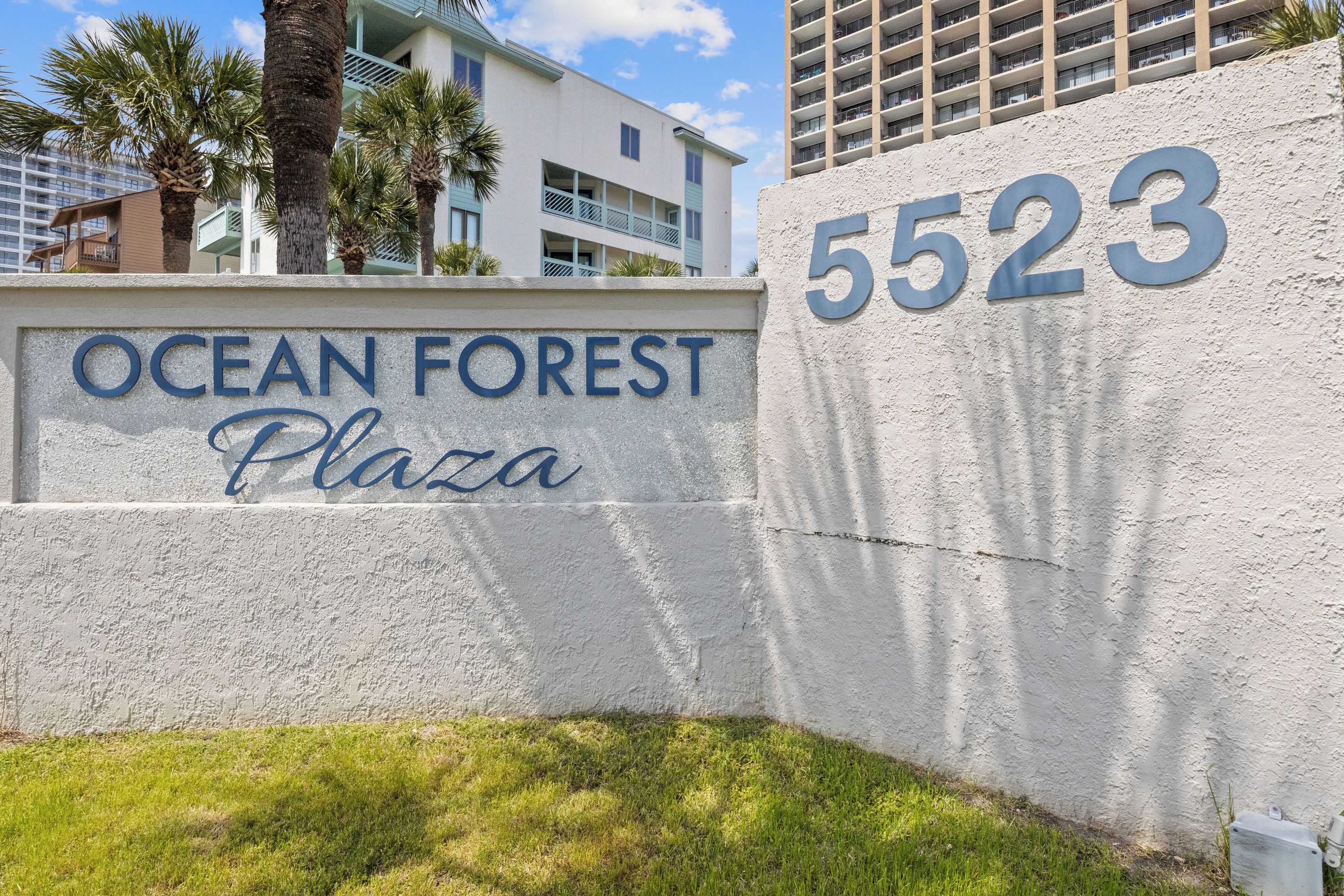 A sign for Ocean Forest Plaza with the address 5523.