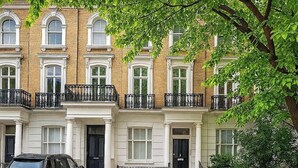 A row of terraced houses with a car parked in front.