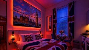 A hotel room with a large bed, a view of a famous clock tower, a small table with a vase, and a washing machine. - London Style (5) Apartment (Greater London)