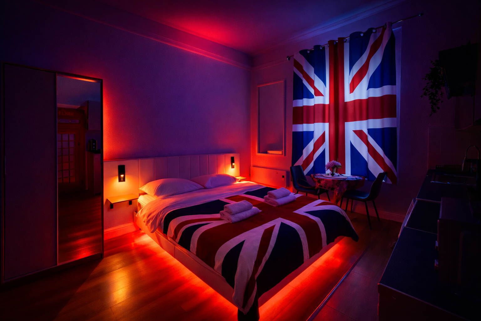 Une chambre d’hôtel avec un lit, des tables de chevet, une chaise, une table avec un vase et un grand drapeau accroché au mur.