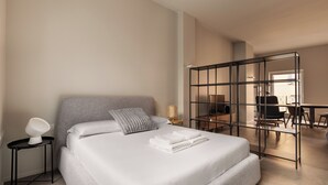 A modern hotel room with a large bed, a desk, and a chair. - DONIZETTI STUDIOS (Bergamo)