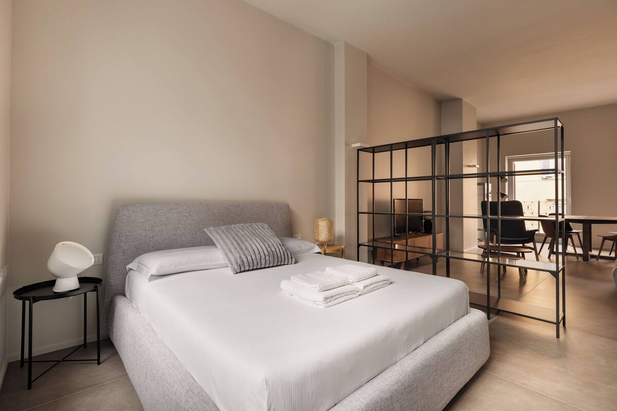 Une chambre d’hôtel moderne, dotée d’un grand lit, d’un bureau et d’une chaise.
