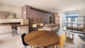 A modern living space with a kitchen, dining area, and seating area. - DONIZETTI STUDIOS (Bergamo)