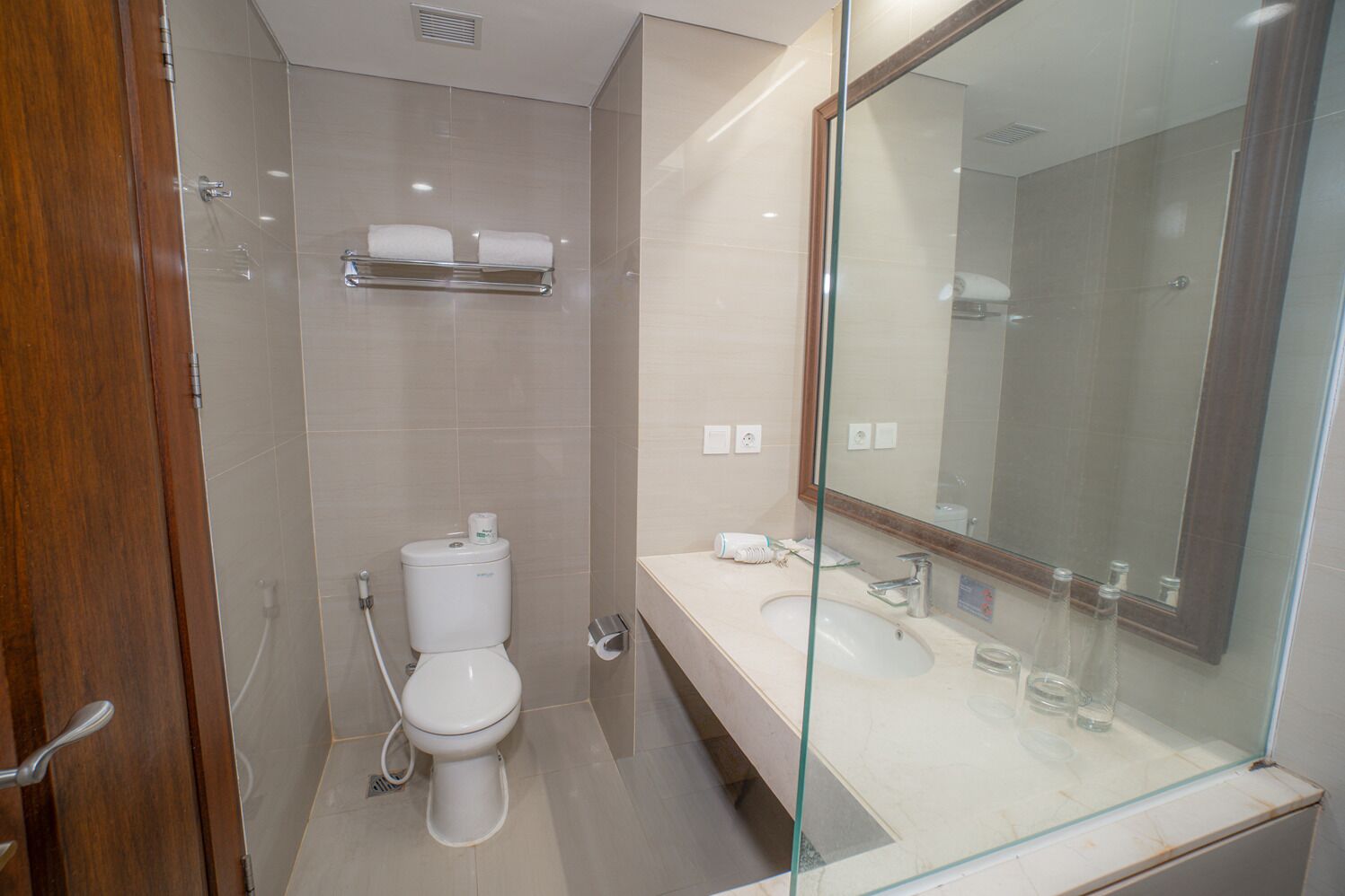 Une salle de bain moderne avec des toilettes, un lavabo et un miroir.