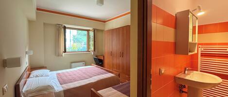 Une chambre à coucher avec un lit, un bureau et une armoire.