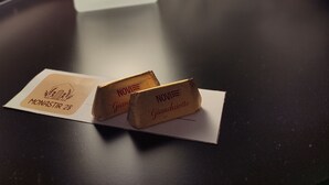 A table with two chocolate bars and a candle.