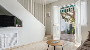 A staircase leading to a balcony with a TV and cactus on the landing.