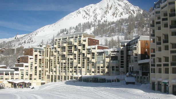 A snow-covered ski resort with multi-story buildings, including a hotel with a ski lift visible. - Modern and cozy studio at the foot of the slopes in Isola 2000 (Isola 2000)