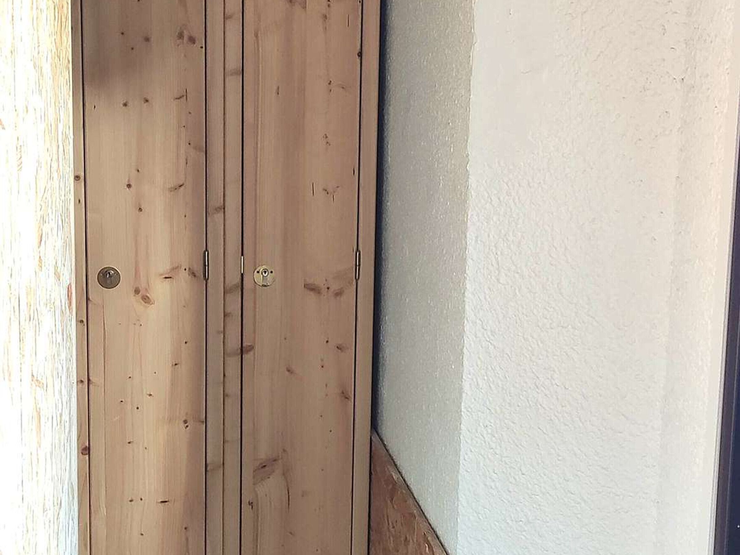 A wooden door with a keyhole and a small lock.