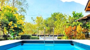 Piscina amb vista a muntanyes i fullatge d'octubre.