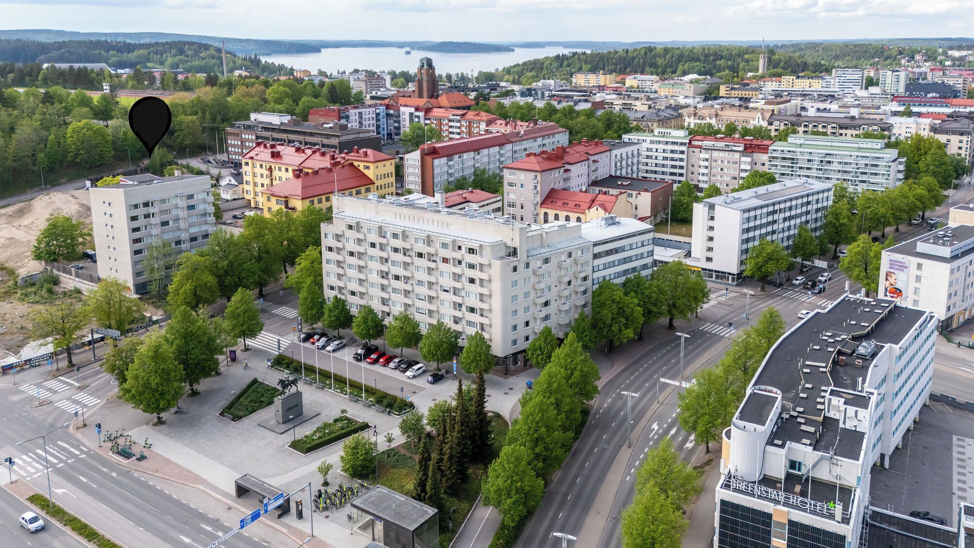 A multi-story hotel with a modern design, located in a city center with surrounding buildings and a view of a body of water.