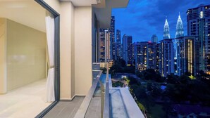 Un balcon offrant une vue sur le paysage urbain, avec de hauts immeubles et un ciel dégagé.