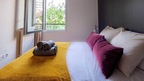 Une chambre à coucher avec un lit, une fenêtre et un radiateur.