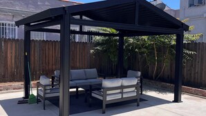 A covered patio with a table and two sofas. - Pet Friendly, Modern, Mins to Retro Row & Beach (Long Beach)