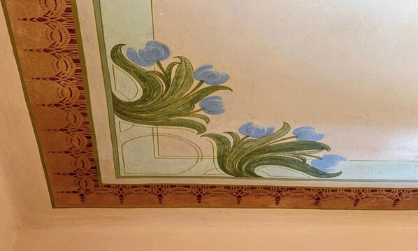 A decorative ceiling with floral patterns and geometric designs.