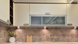 A modern kitchen with dark wooden cabinets, a stainless steel oven, and a built-in dishwasher.