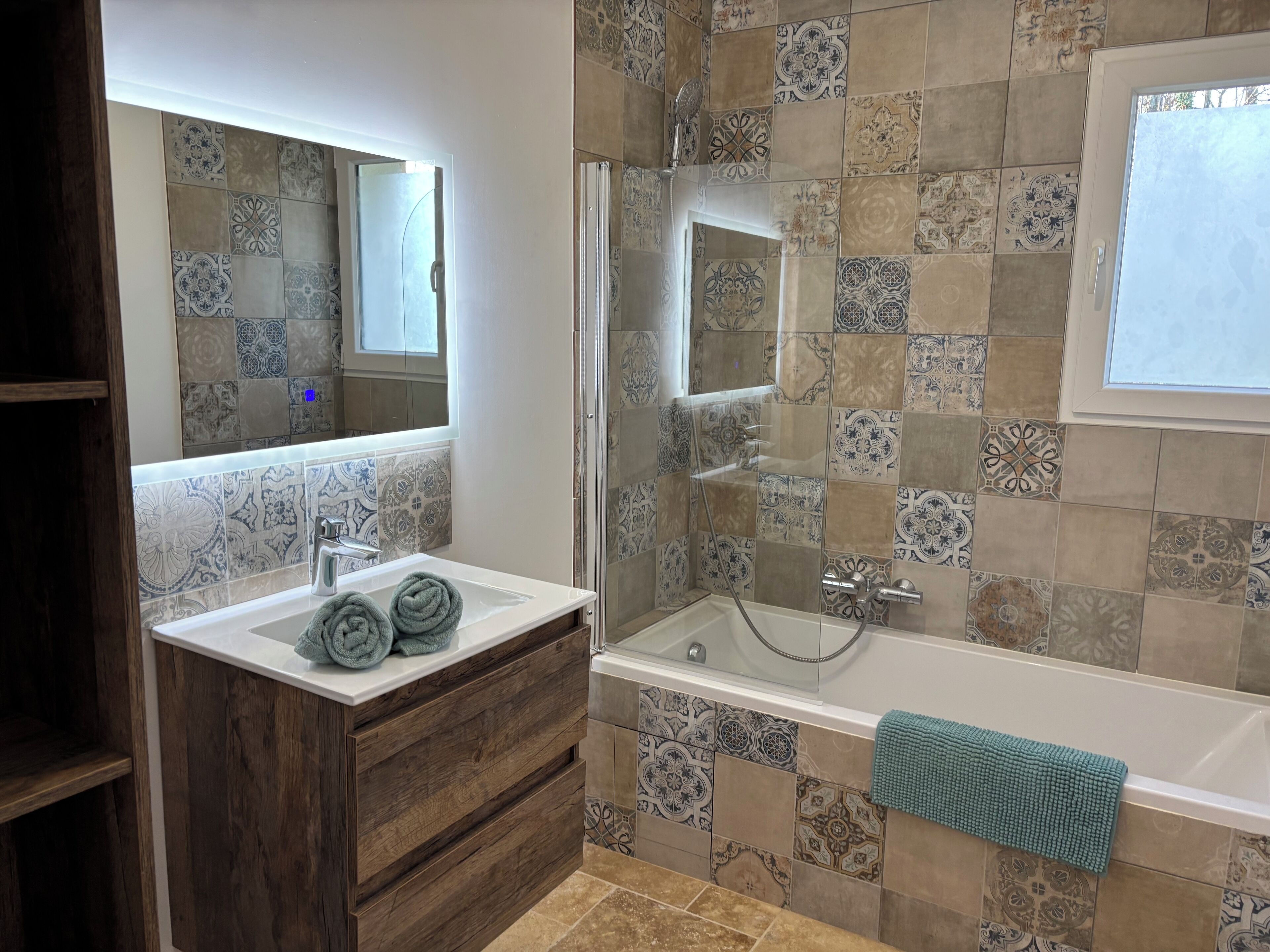 Ein Badezimmer mit Holztresen, einer Badewanne und einer Duschkabine.