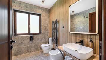 Un bagno moderno con un'ampia finestra, un lavabo sospeso e un water.