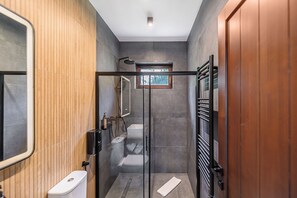 A modern bathroom with a glass shower enclosure, a toilet, and a towel rack. - Eskaperdo Resort (Zetea)