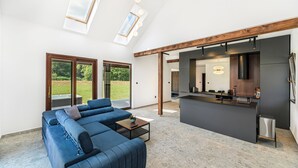 Ein modernes Wohnzimmer mit einer Eckcouch, einem Couchtisch und einer Küchenzeile mit Bar.