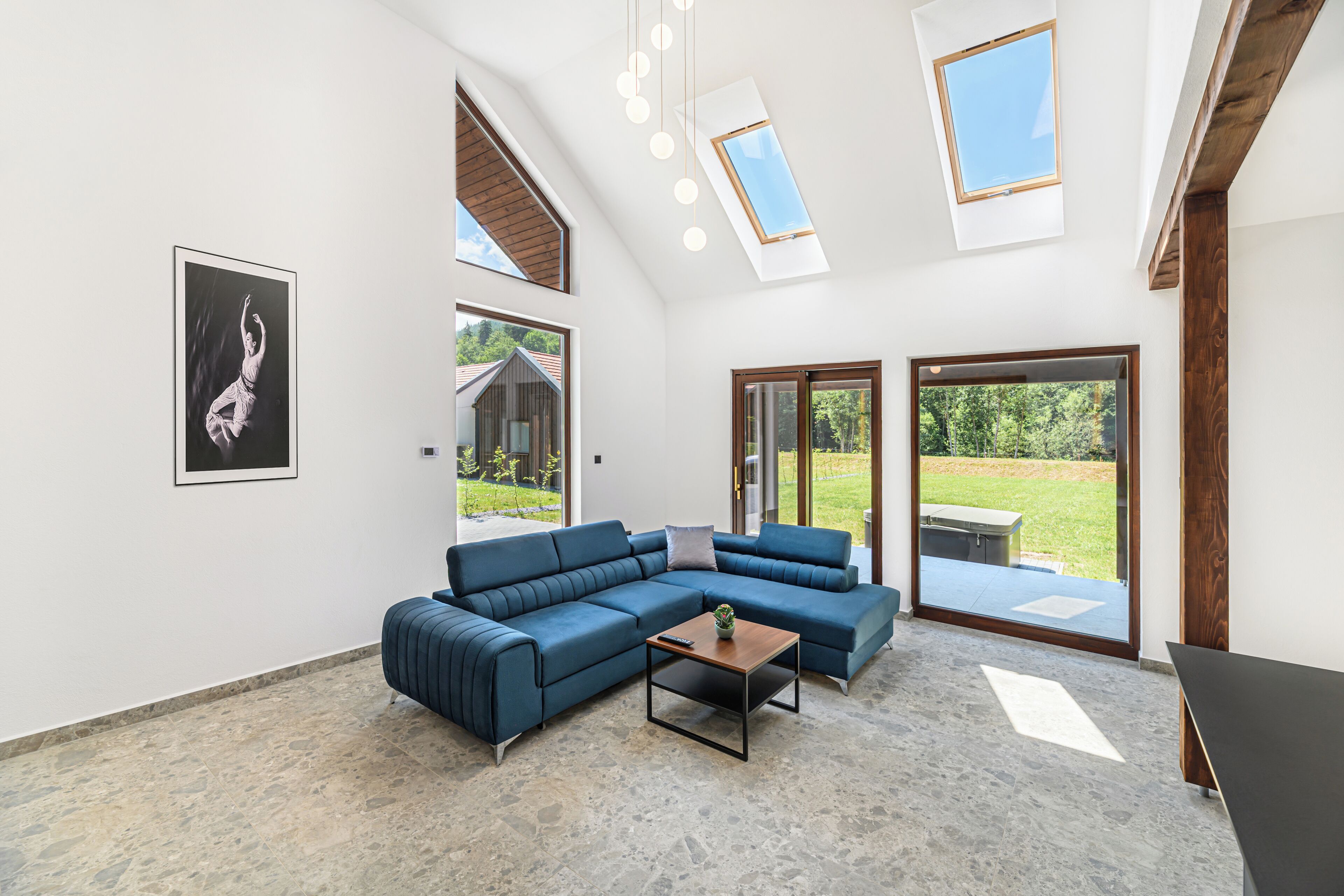 A modern living room with a sectional sofa, a coffee table, and skylights.