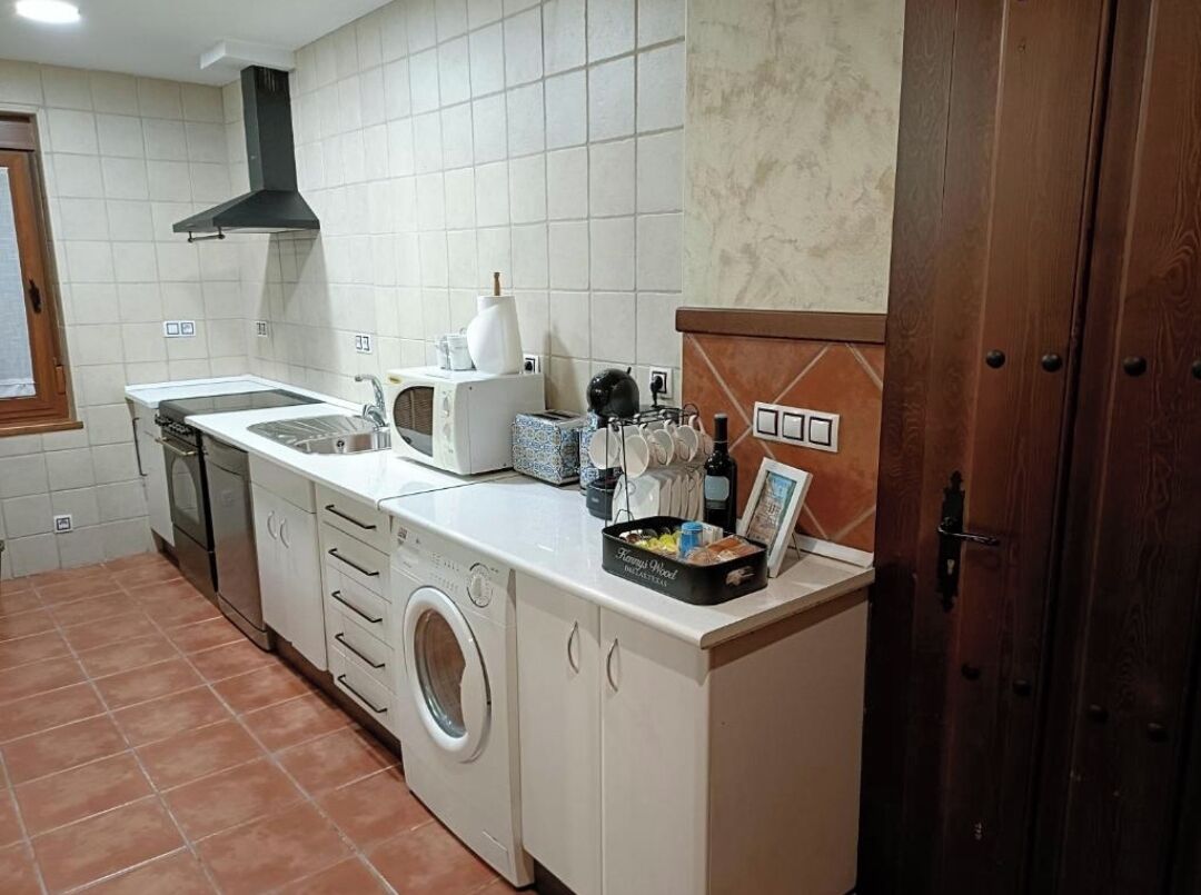 Cocina compacta con lavadora, estufa y microondas.