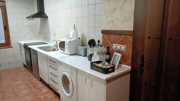 Cocina compacta con lavadora, estufa y microondas.