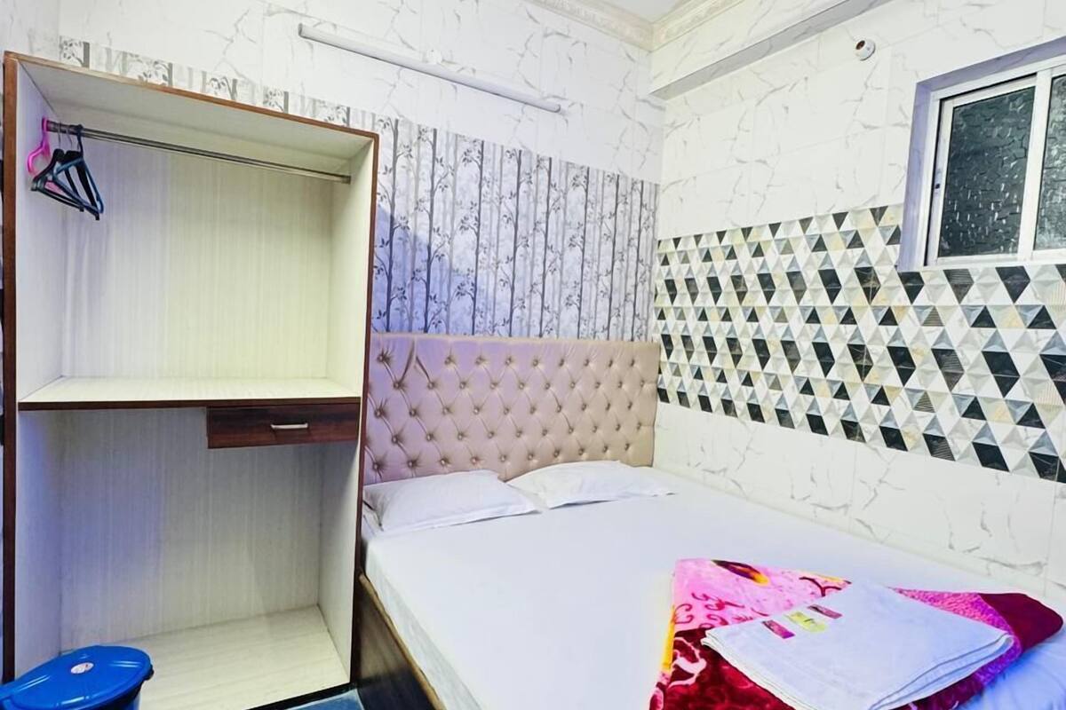 Une chambre à coucher avec un lit, un ventilateur de plafond, une armoire et une fenêtre.
